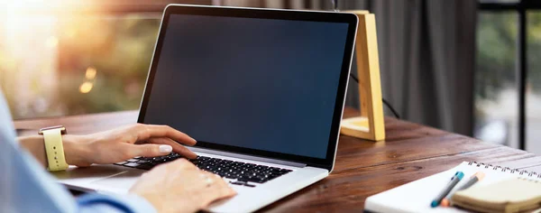 Mockup image of a woman using laptop with blank screen on wooden — Stockfoto