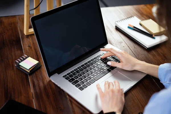 Imagem Mockup de uma mulher usando laptop com tela em branco em madeira — Fotografia de Stock