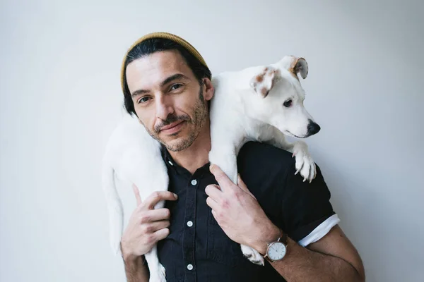 Portrait studio d'un beau mec tenant son chien — Photo