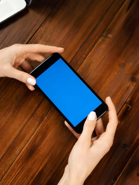 Primer plano de la foto de manos femeninas sosteniendo el teléfono inteligente horizontalmente . — Foto de Stock