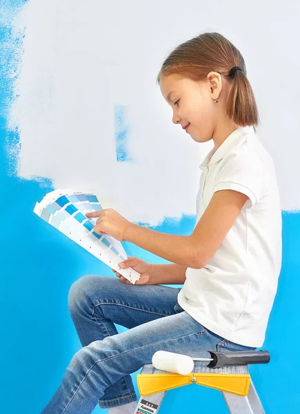 7 år gammal flicka att välja en färg för väggen i hennes rum — Stockfoto