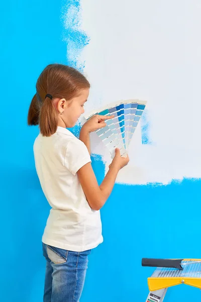 7 anos de idade menina escolhendo uma cor para a parede em seu quarto — Fotografia de Stock