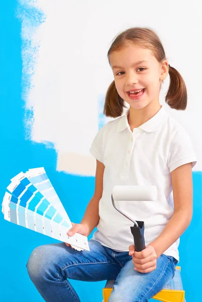 Mädchen mit Farbmustern und Farbroller neben einer Wand — Stockfoto