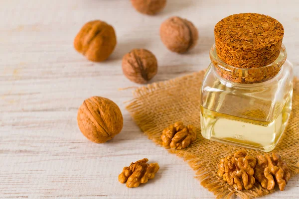 Walnut oil and nuts on clean background — Stock Photo, Image