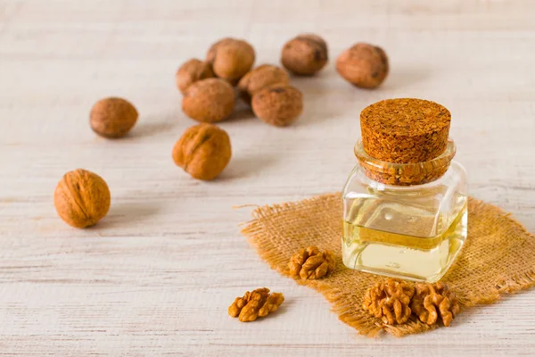 Walnut oil and nuts on clean background — Stock Photo, Image