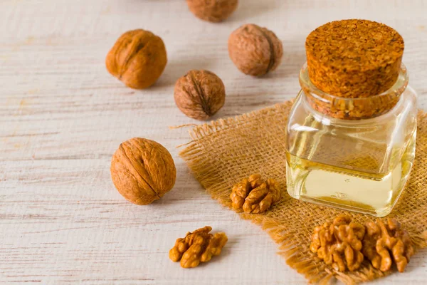 Walnut oil and nuts on clean background — Stock Photo, Image
