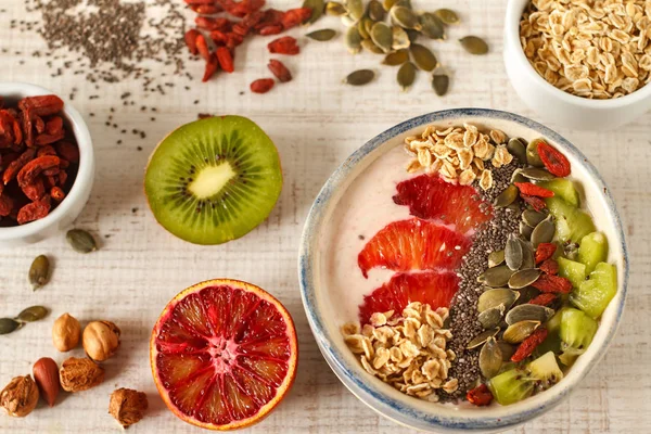 Yogurt with red orange, kiwi, chia seeds, nuts and oats — Stock Photo, Image