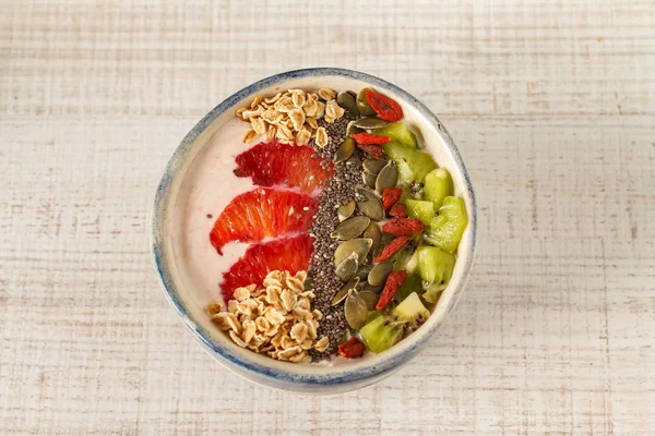 Yogurt with red orange, kiwi, chia seeds, nuts and oats — Stock Photo, Image