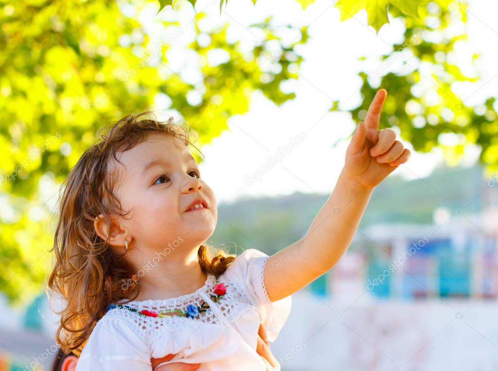 Little girl pointing the green leaves