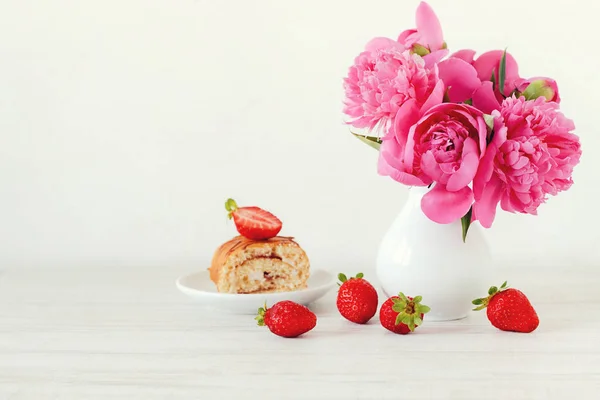 Natura morta con peonie rosa, fragole e torta — Foto Stock