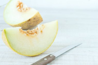 Ahşap masanın üzerine dilimlenmiş taze kavunlar