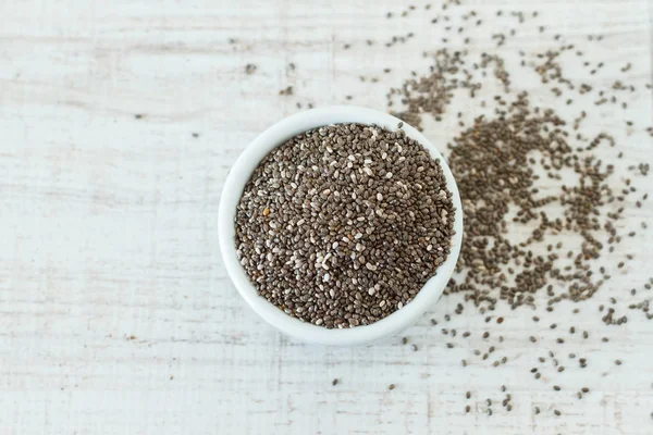 Superfood: chia zaden in een witte kom, bovenaanzicht — Stockfoto