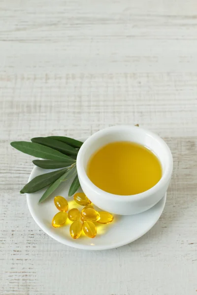 Маленькая миска с оливковым маслом и природными таблетками — стоковое фото