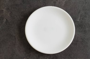 Koyu arka plan üzerinde beyaz küçük boş tabak