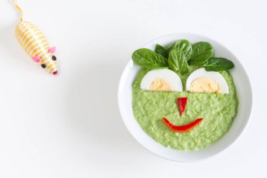 Kase pureed yeşil sebze ile mutlu yüz yumurta ve sebze tarafından yapılan bebek için