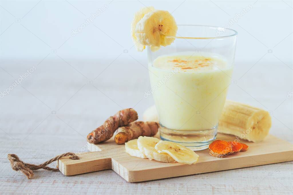 Banana Smoothie with turmeric on a wooden table