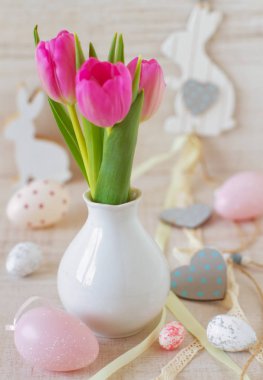 Yumurtalarla, tavşanlarla ve pastel renklerde çiçeklerle süslenmiş güzel bir Paskalya sofrası.