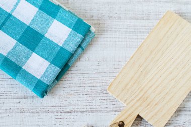 Boş mutfak kesme tahtası ve ahşap bir masa üzerinde kırsal havlu, üst görünüm