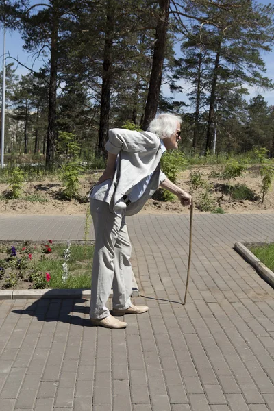 Na caminhada de um homem idoso com dor nas costas — Fotografia de Stock