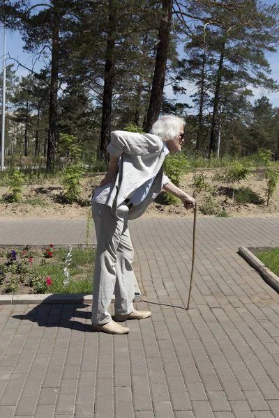 Na caminhada de um homem idoso com dor nas costas — Fotografia de Stock