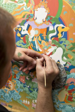 The artist paints a Buddhist icon clipart