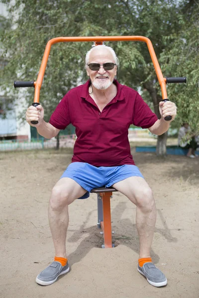 Starší muž vlaky na sportovní vybavení na čerstvém vzduchu — Stock fotografie