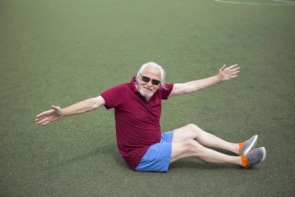 Senior man exercising in an open stadium — Stock Photo, Image