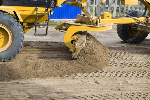 Motor grader aligns the road Royalty Free Stock Images