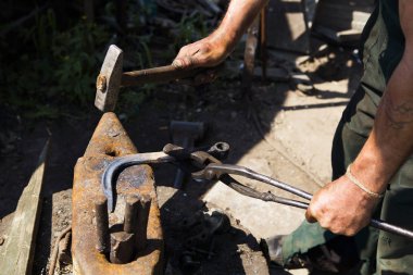 Demirci ile bir çekiç örs üzerinde çalışır