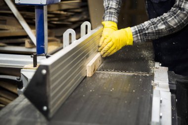 Marangoz ahşap ürün imalatı makine çalışır. Marangoz ahşap çeşitli konfigürasyonları tezgahı üzerinde keser.