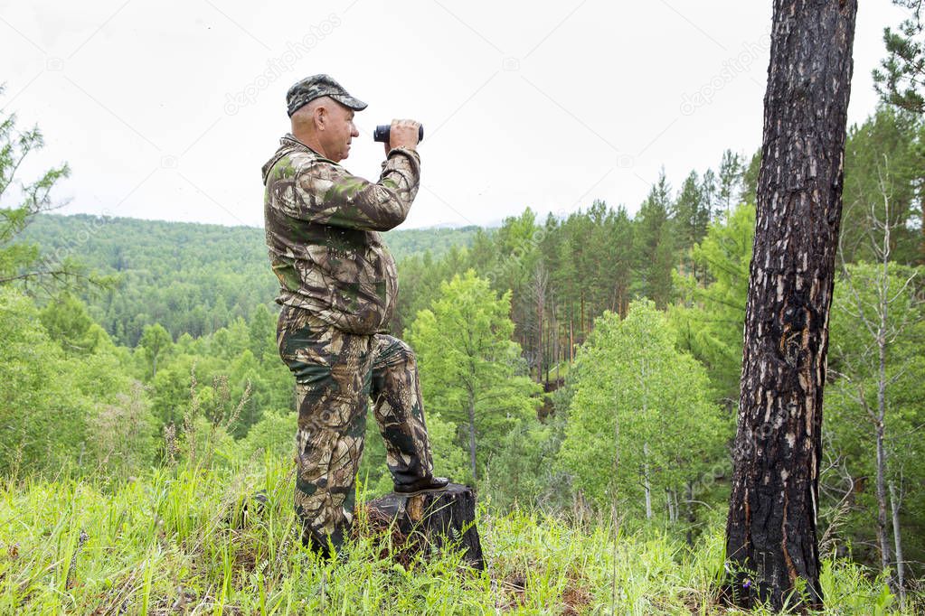 the forester looks through binoculars