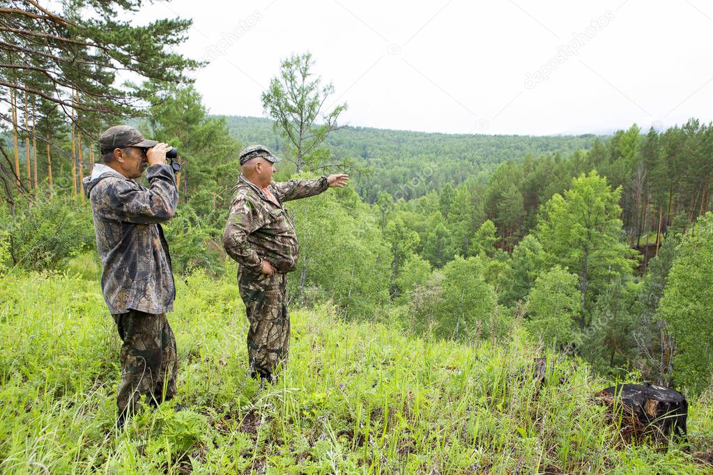 the forester looks through binoculars