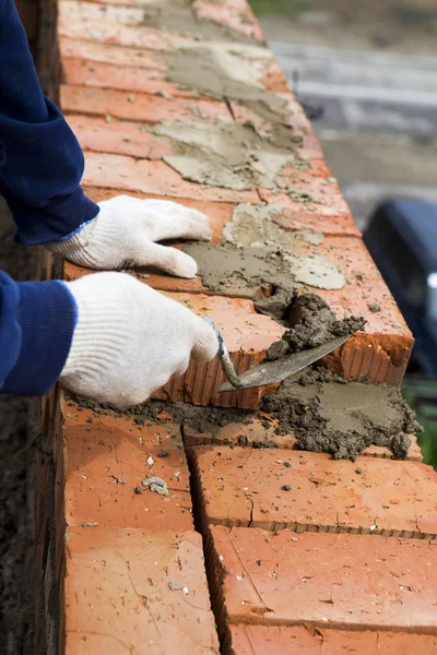 Construction mason worker bricklayer installing brick