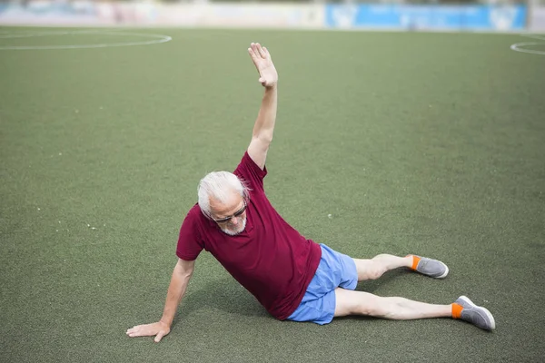 Старший чоловік тренується на відкритому стадіоні — стокове фото