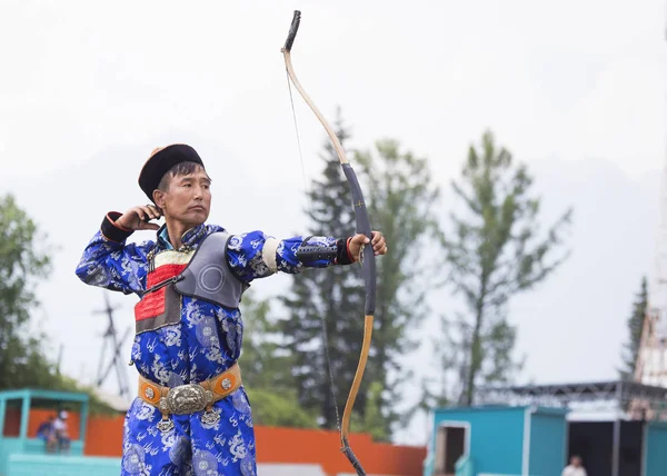 Young man shoots from a sports bow