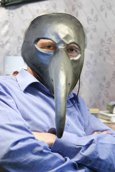 Portrait of a man in a plague mask in a working environment