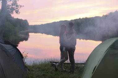 Aşıklar nehirde gün batımına hayrandır.