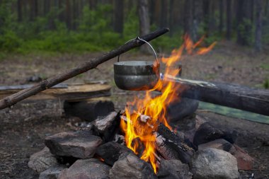 Bir tencerede ateşte yemek pişirmek