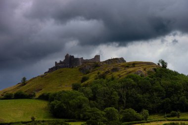 Carreg Cennen kalesi bir tepede. Dramatik bir gökyüzü. Galler, Uk.