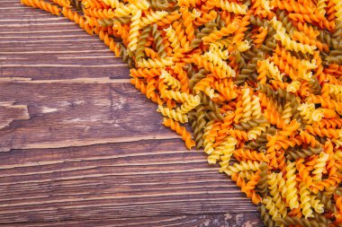  ahşap arka plan üzerinde farklı renkteki kuru fussili makarna