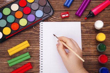 Boş defter, okul malzemeleri ahşap Resepsiyon arka plan üzerinde brushwith çerçevesinde eliyle açıldı. Geri okul kavramı.