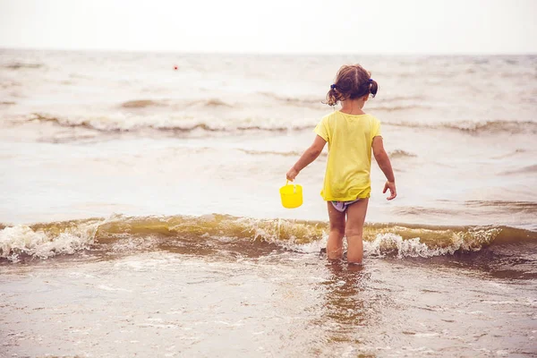 A vödröt a kislány jön a tengerbe — Stock Fotó