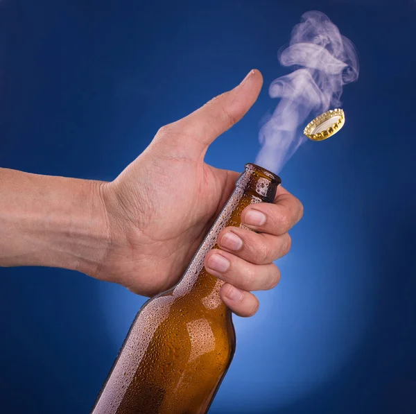 Hand opens a bottle of cold beer — Stock Photo, Image