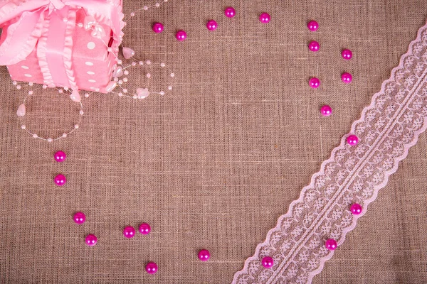 Background of burlap with pink git box and pink lace — Stock Photo, Image