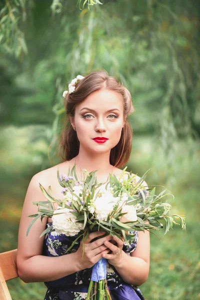 Piękna młoda kobieta z bukietem kwiatów w swoje ręce — Zdjęcie stockowe