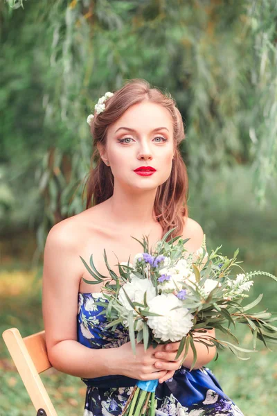 Mooie jonge vrouw met een boeket bloemen in hun handen — Stockfoto