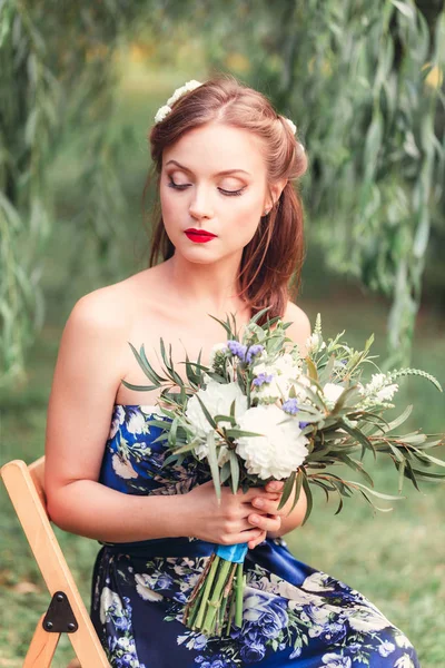 Красива молода жінка з букетом квітів в руках — стокове фото