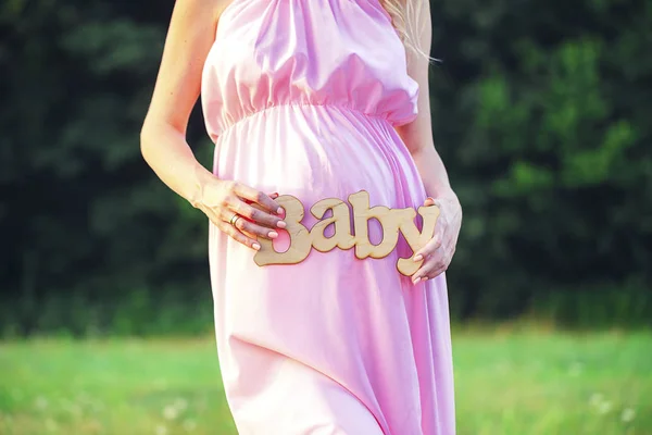 임신한 여자의 손에 레이블 "아기" — 스톡 사진