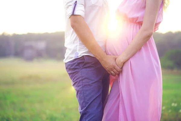 The image of a pregnant couple. Husband and wife holding hands a — Stock Photo, Image