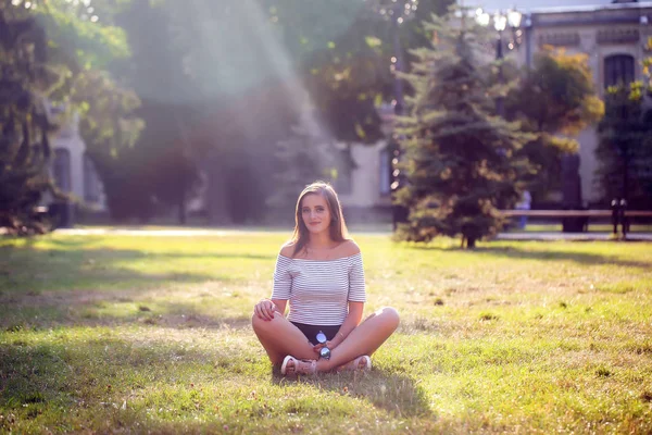 Jeune belle femme heureuse assise sur l'herbe — Photo